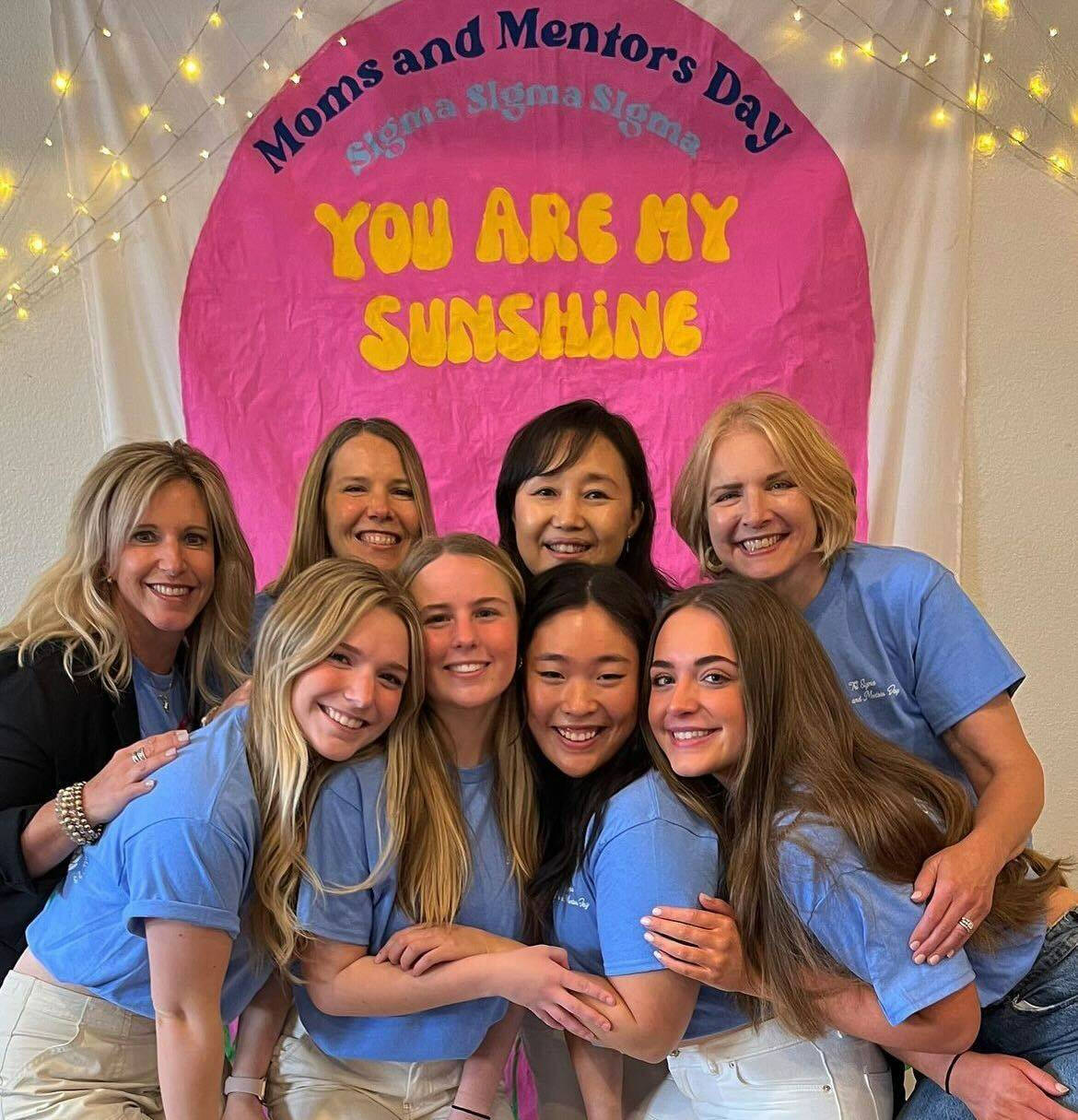 Sorority members posing with their parents and supporters.